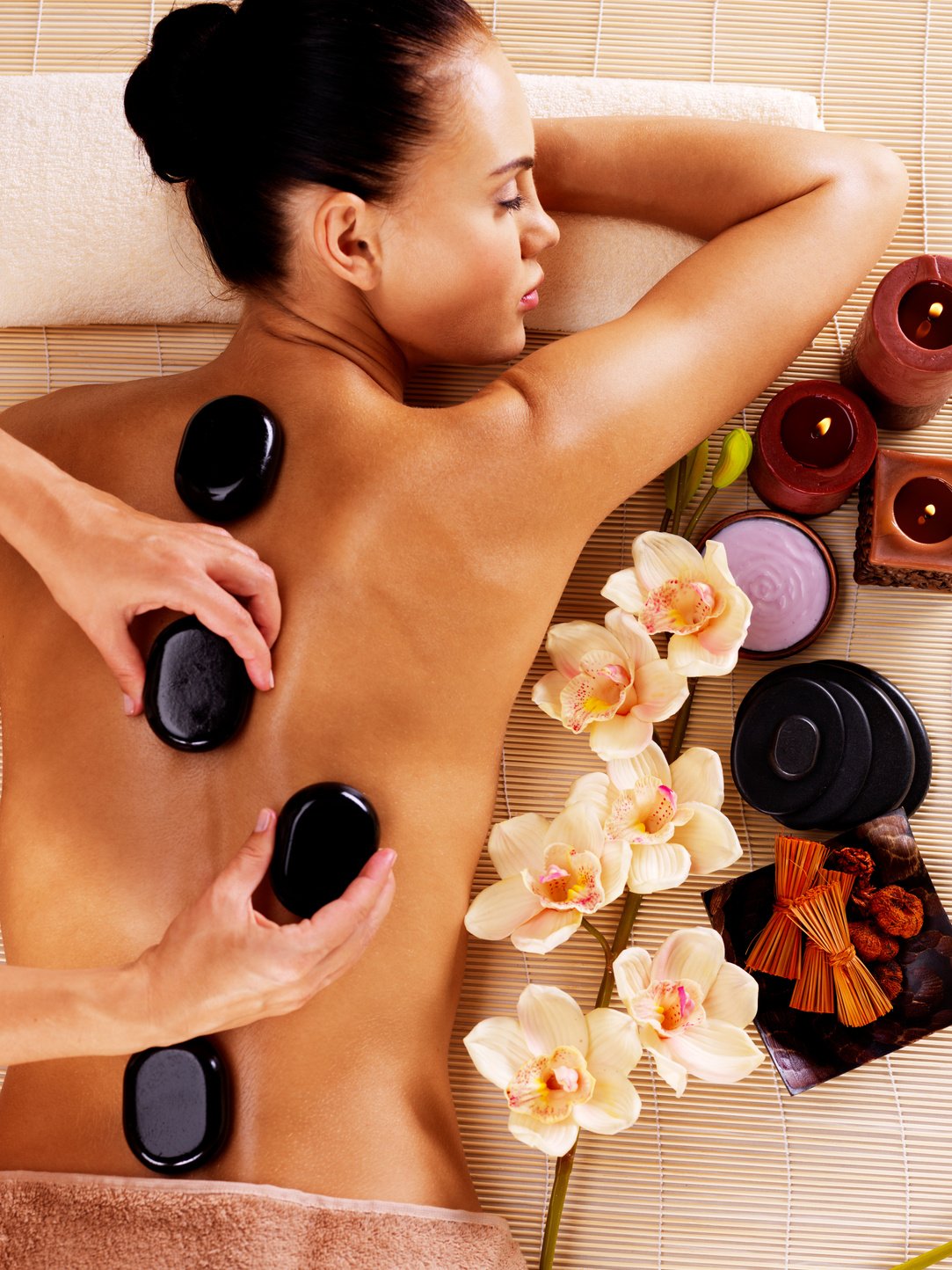 Adult Woman Having Hot Stone Massage in Spa Salon